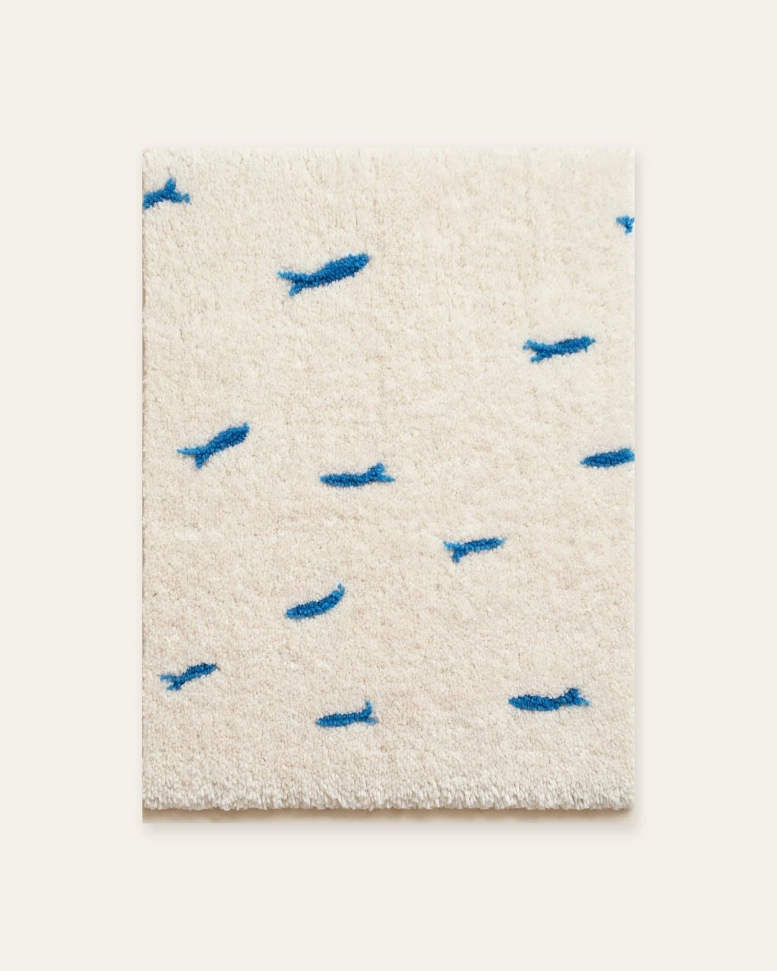 Little Blue rug, full view: small blue fish scattered across an ivory field